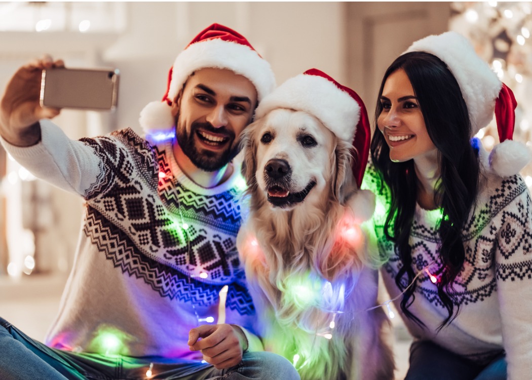 A young couple with their golden retriever is snapping a selfie because they don't have to worry about checking account fees.