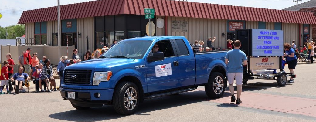 Pickup truck pulling a sign in a parade