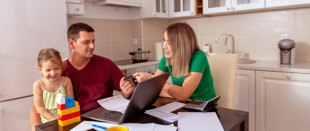 family sitting at table paying bills 