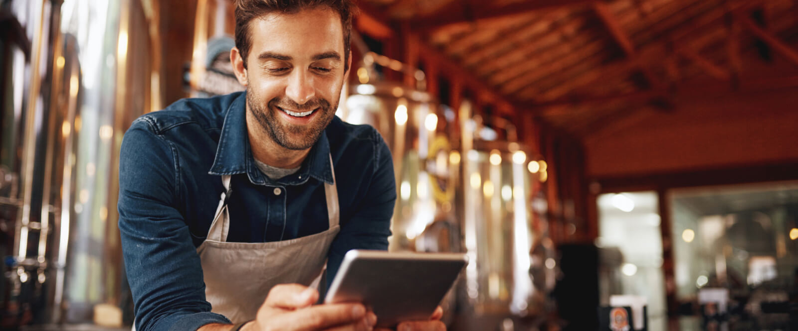 man in an apron using a tablet