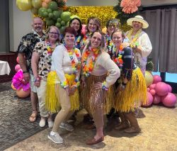 Employees from Citizens State Bank dressed in Hawaiian attire celebrating at the St. Croix Central Chamber Luau.