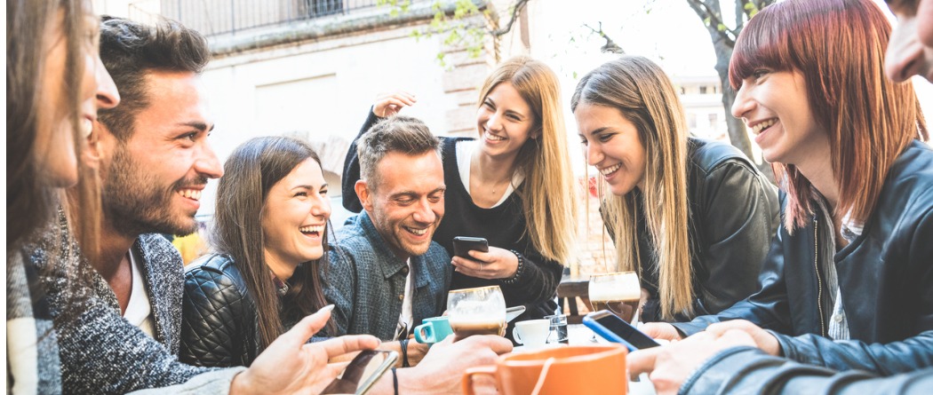 A group of friends eating out on their phones.