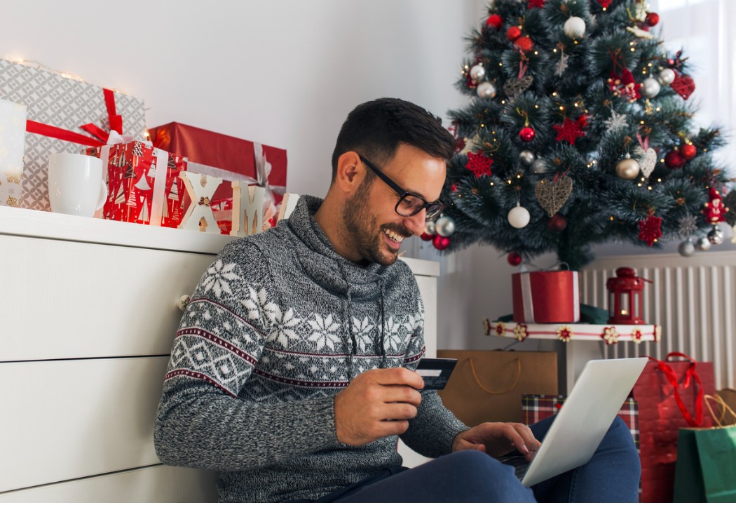 A young man is buying gifts online using his CSB debit card. 